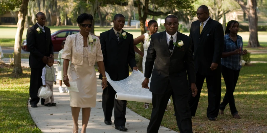 several men and women wearing suits walking with the bride in her wedding gown