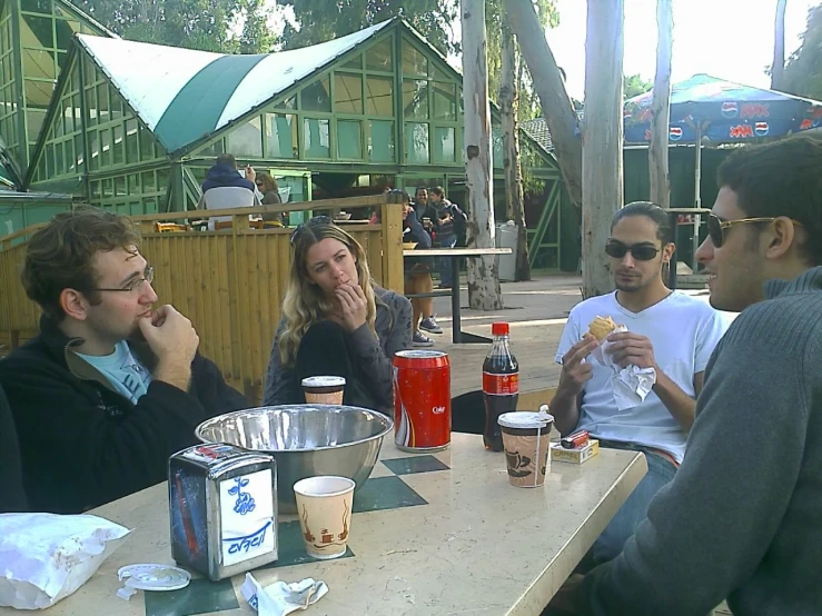 a group of friends eating pizza and talking to each other