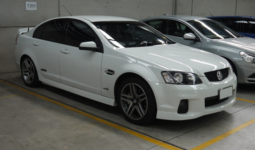 a group of three different vehicles parked inside a garage