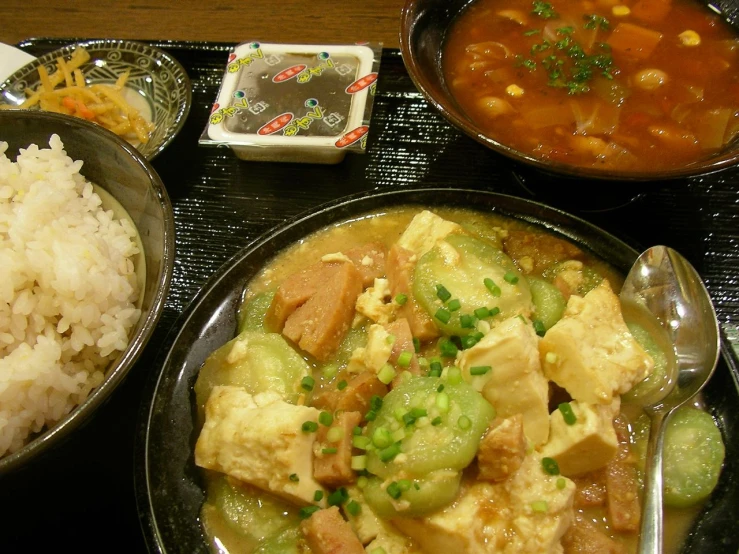 a plate of food with a spoon, rice and other food items