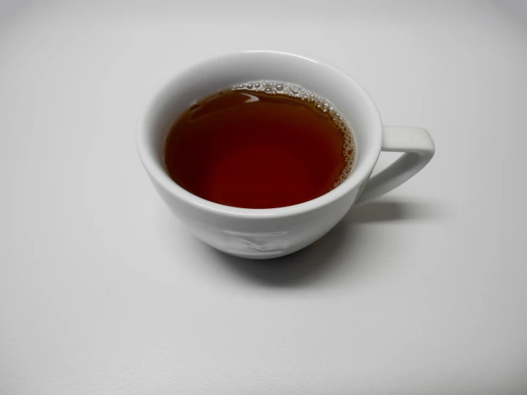 a white cup filled with liquid on top of a table