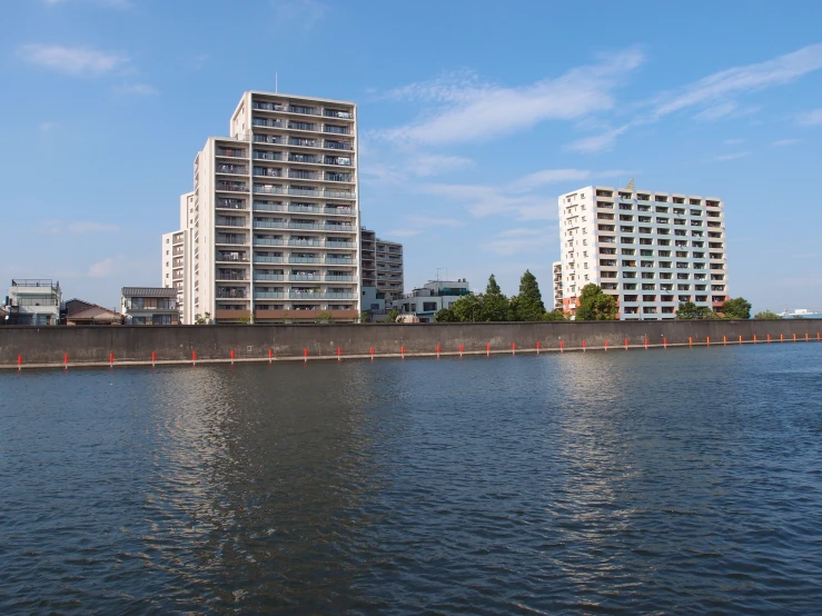 a large lake with a row of white buildings behind it