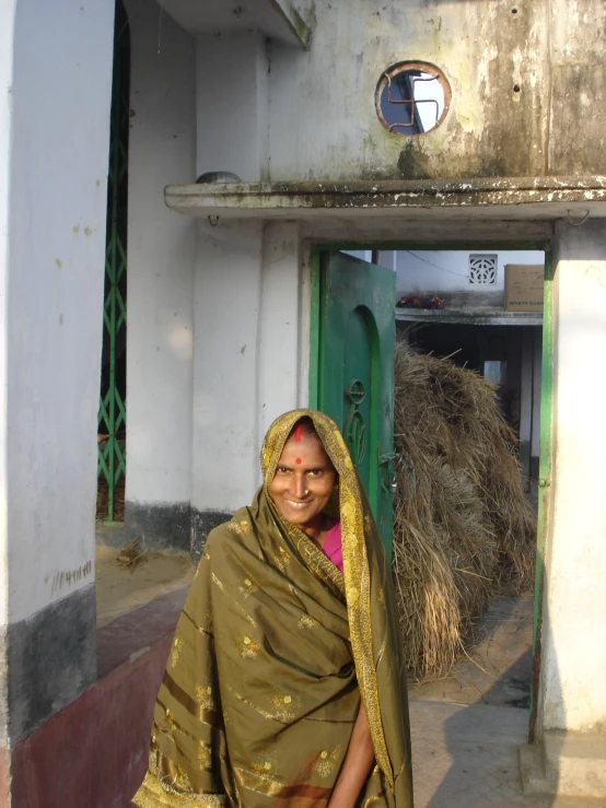 a woman in a green sari standing on the street