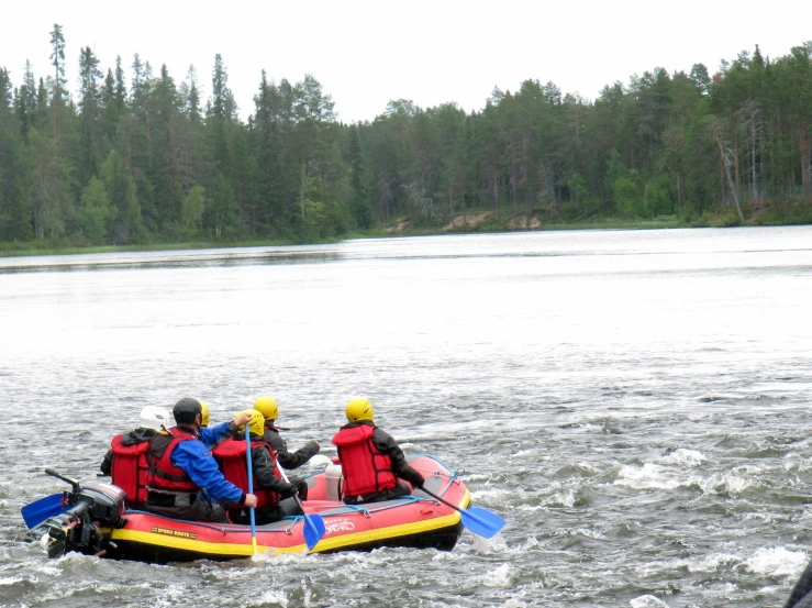 several people with life vests on raft in lake