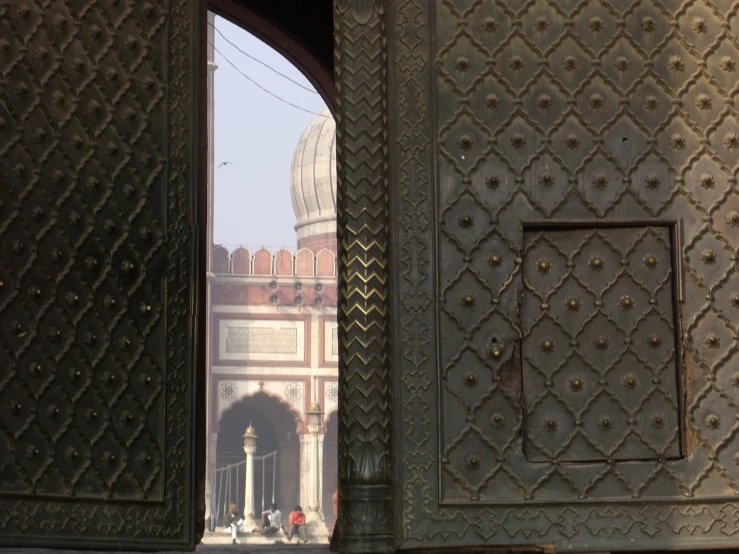 an open door leading to a building with large ornately decorated door