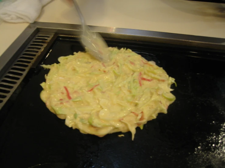 a mixture of food being stirred on top of a grill