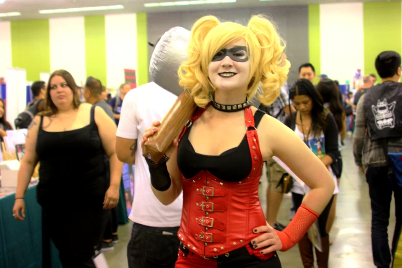 a woman in a red corset holds a metal ball