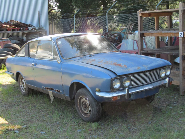 an old car is rusted in a yard