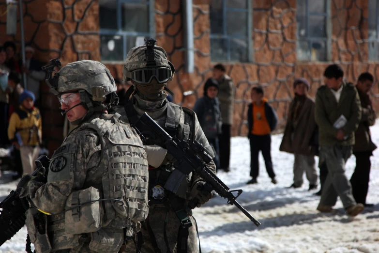 people are in the snow walking with some military gear