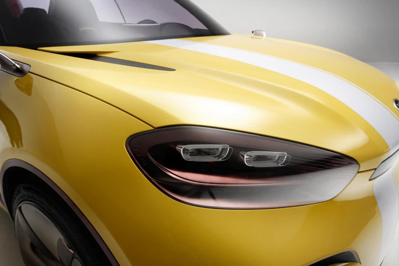 a close up of a yellow sports car with white stripes