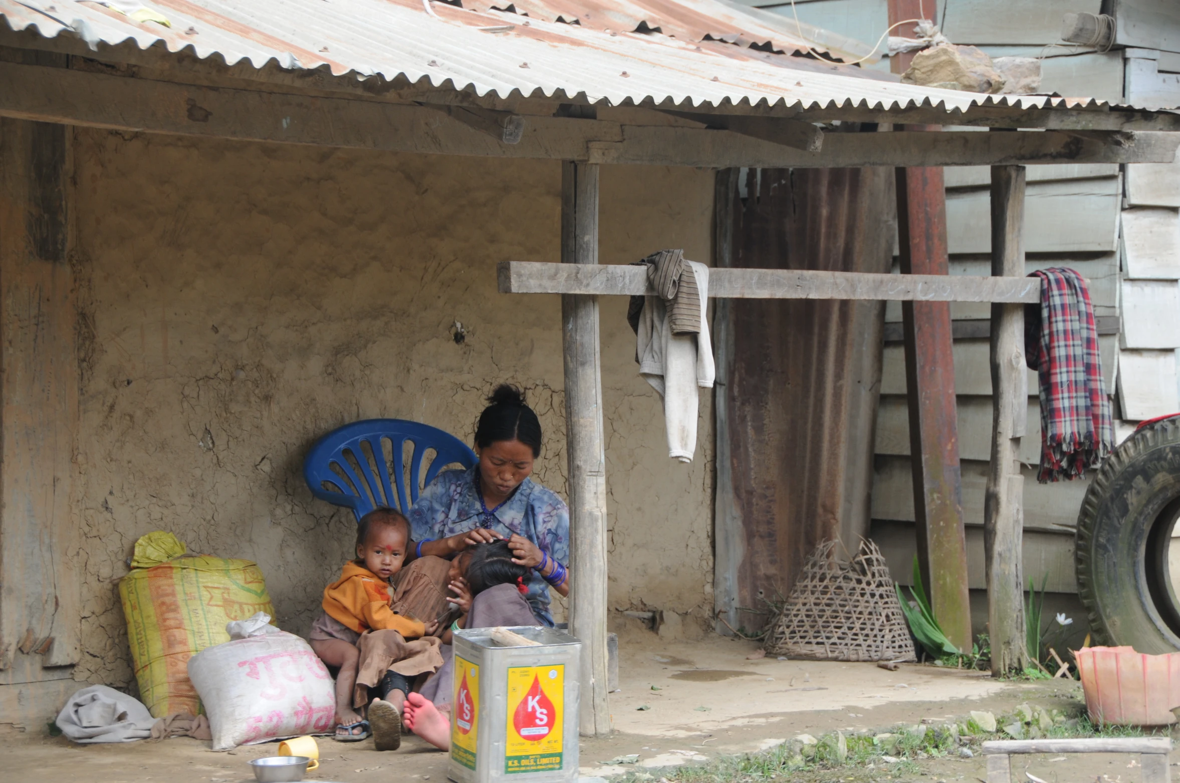 a woman is sitting down on her phone and another lady near her house