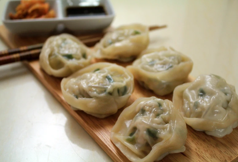 some dumplings with vegetables in a wooden tray on a  board