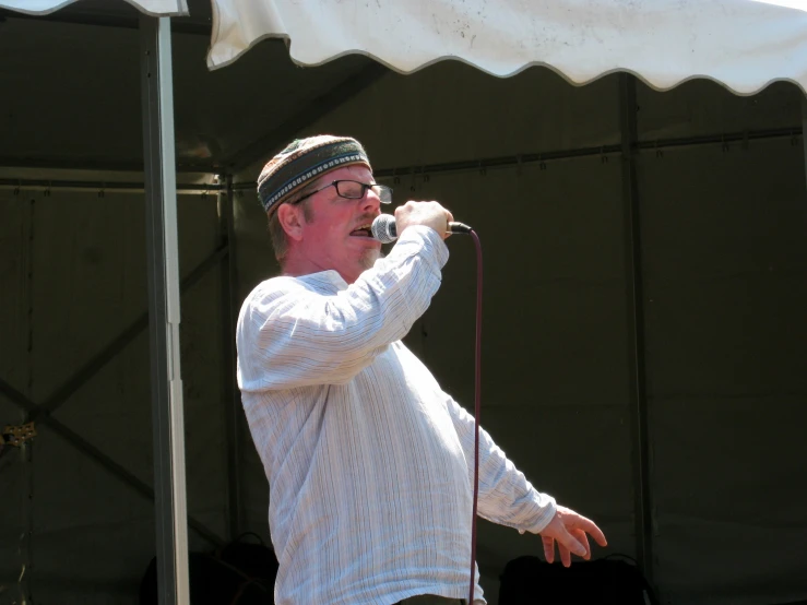 man in a hat singing on a stage