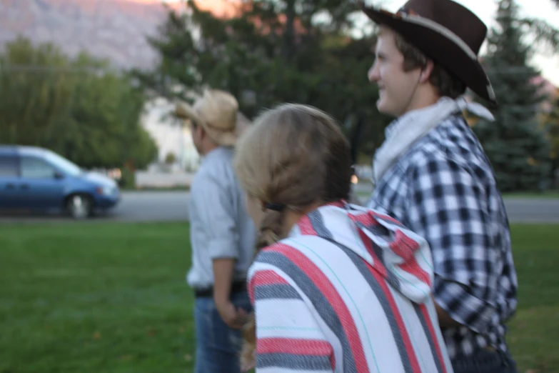 three people that are standing in the grass