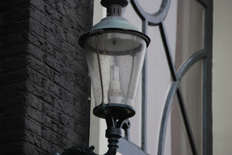 an old style street light hanging off the side of a building