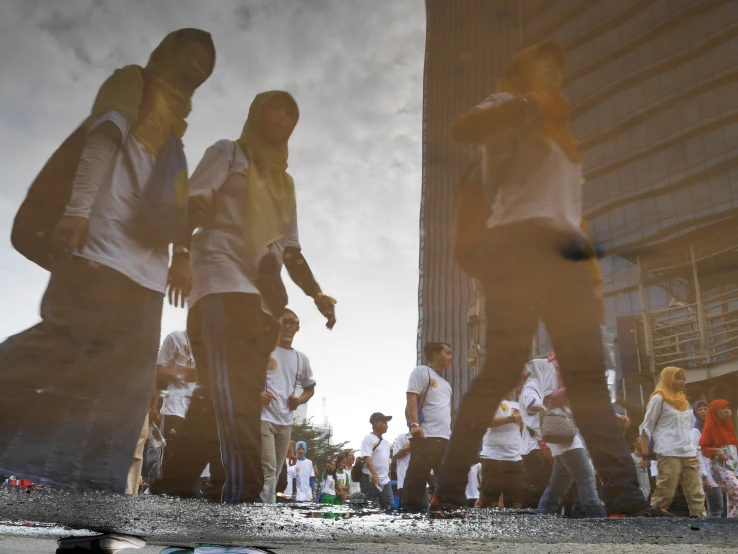 a reflection of people on the sidewalk in the background