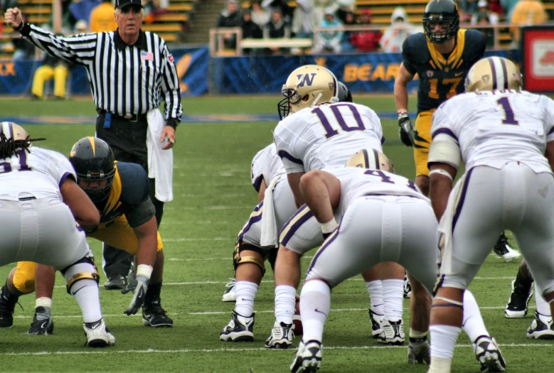 a football game in progress with the referees behind the team