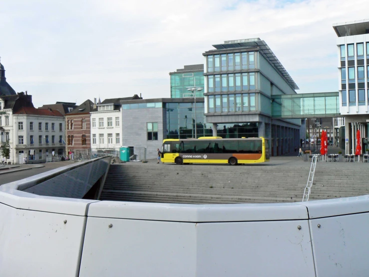 yellow transit bus parked in front of buildings