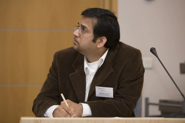 a man sitting at a desk with a pencil in his hand