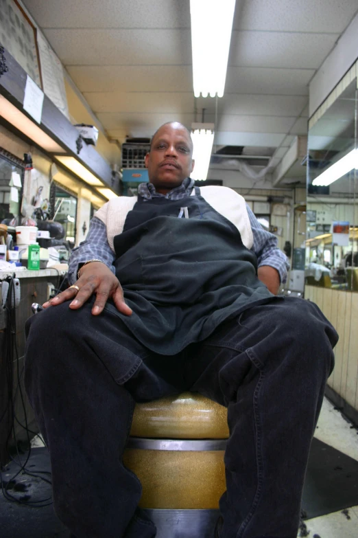 a man that is sitting down on a stool