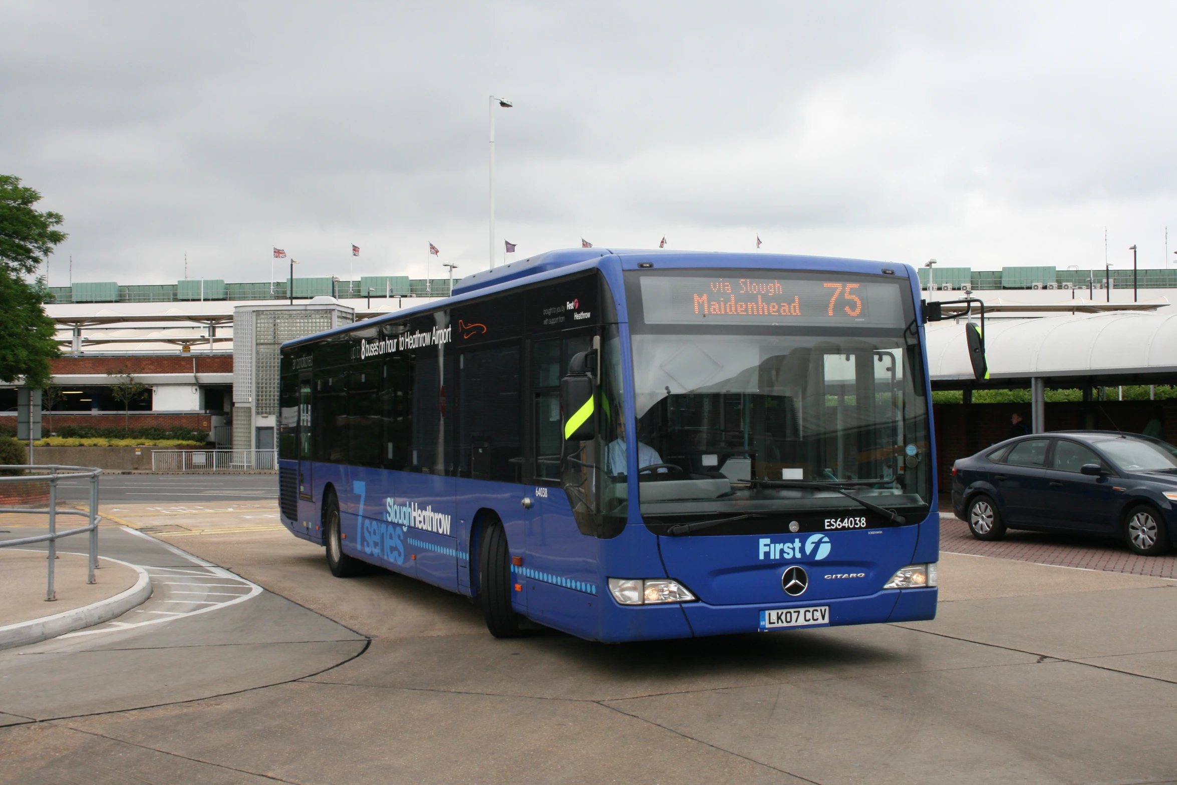 a blue bus driving down a street in front of buildings