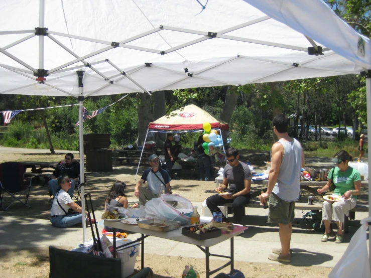 people eating under a canopy for shade under the tent