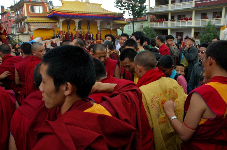 monks in robes gather around in a temple