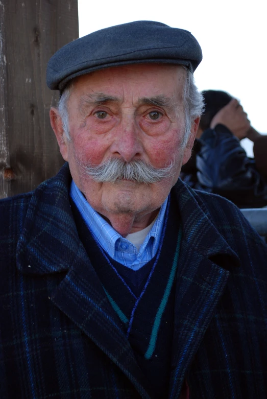 an old man with a blue suit and hat