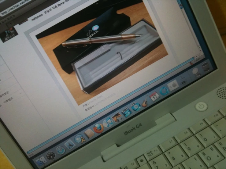 a laptop computer with a pen sitting on top of it