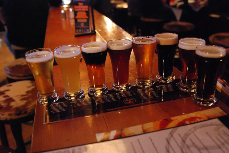 a row of beer flight glasses filled with beer