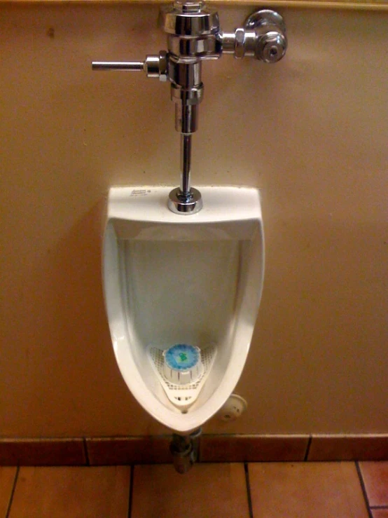 a white urinal in a restroom on a wall