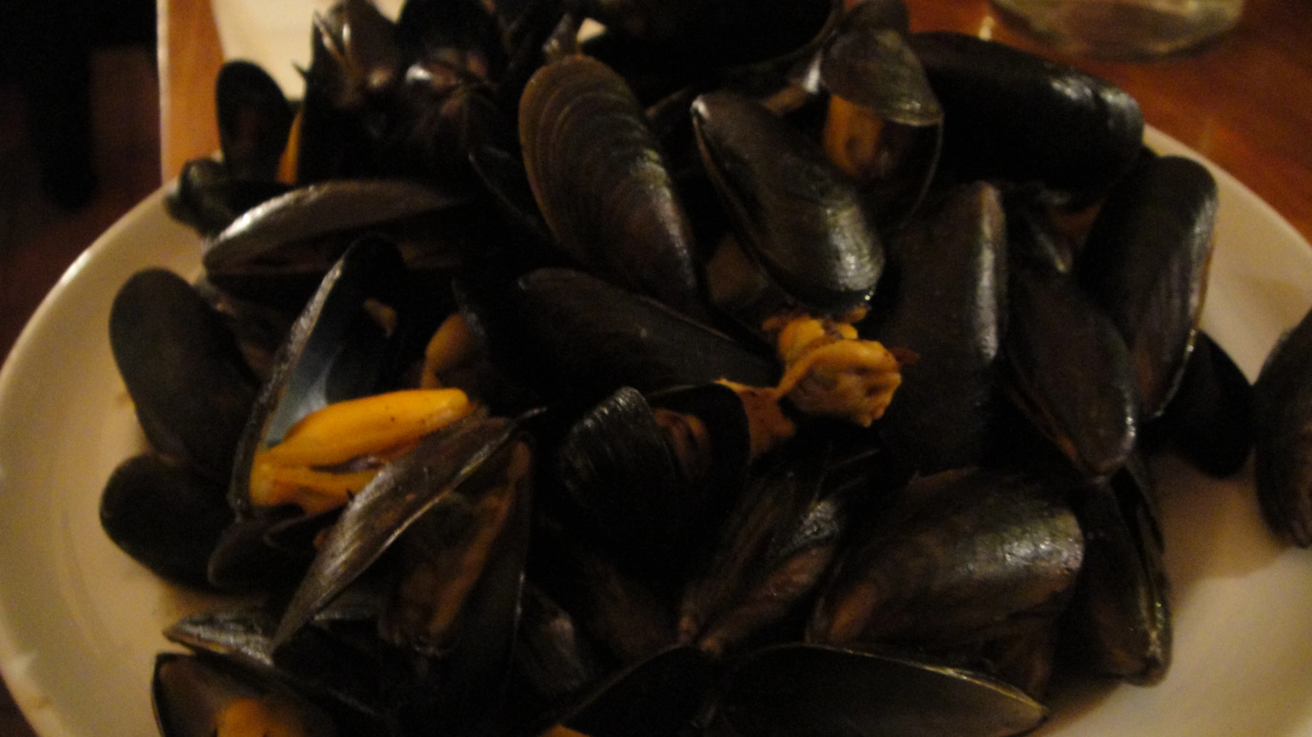 a white plate topped with mussels and orange slices