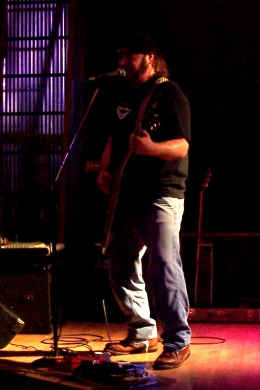 a man standing on stage holding a guitar