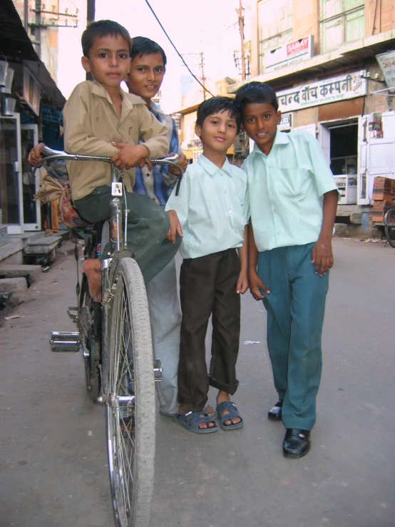 a group of boys are standing near a bike
