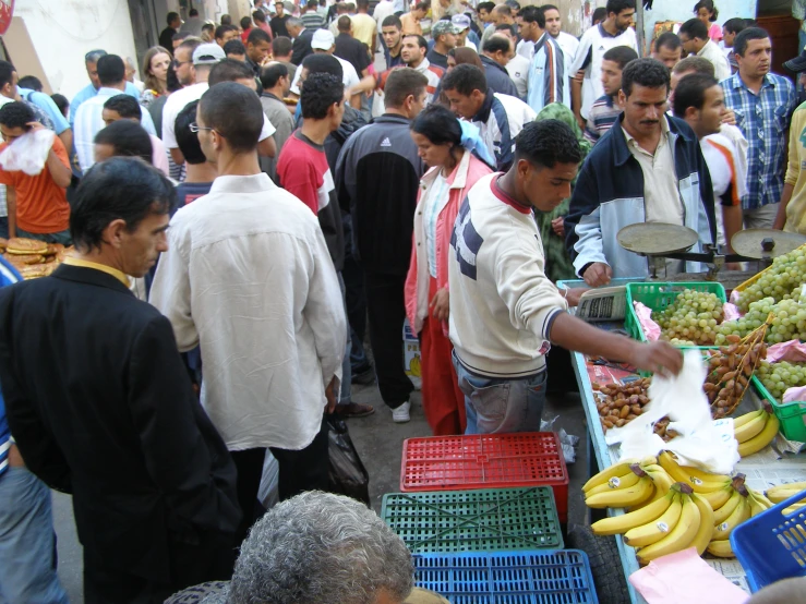 many people are shopping for produce at the market