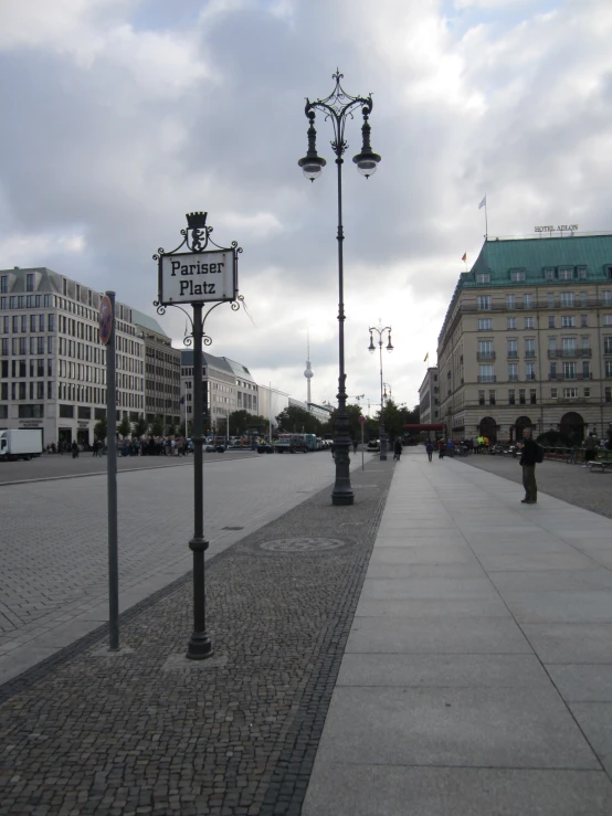 a street with two black and white light poles and a red sign