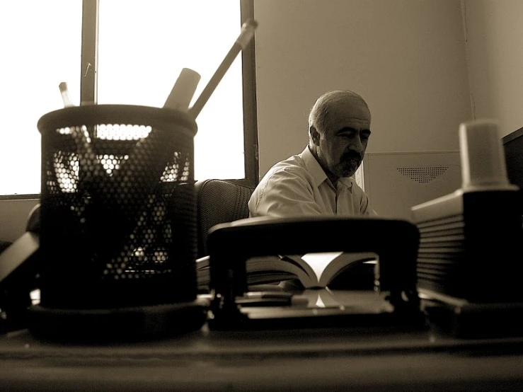 a man sits at his desk with papers in front of him