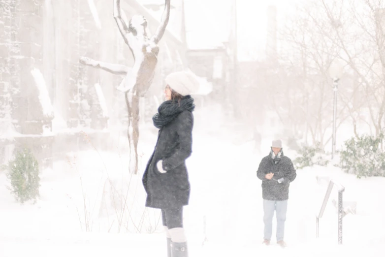 people standing in the snow looking at a tree