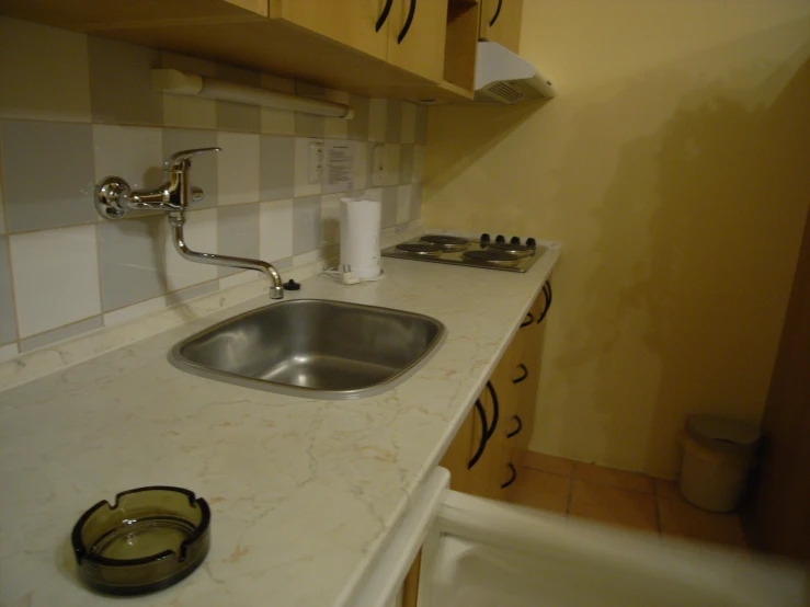 an image of kitchen with sink and soap dispenser