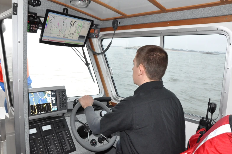 a man sits in the helm while he is on a ship