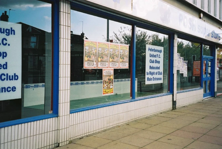 a shopfront window displays some signs in the windows