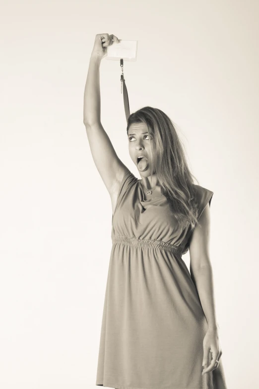 a woman poses with her arms in the air as she holds a plastic object in her right hand