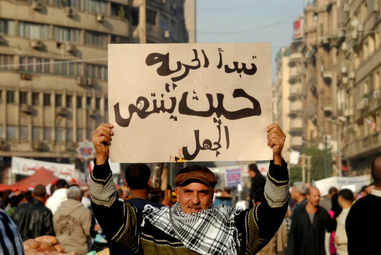 a protester holding up an islamic sign in a crowd