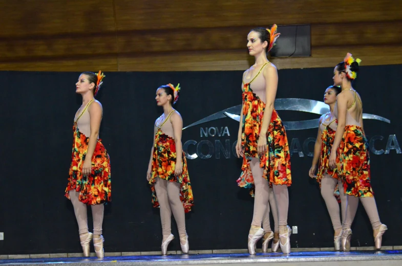 four young women in colorful outfits walking on the runway