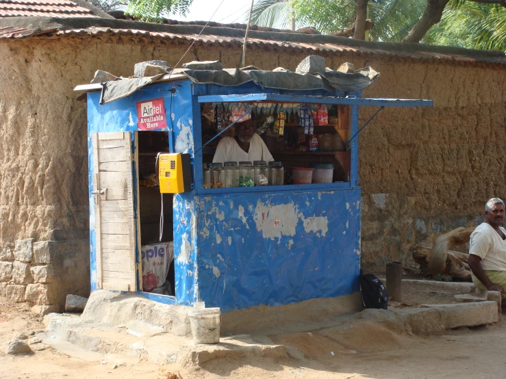 a man sitting on the steps by his shop