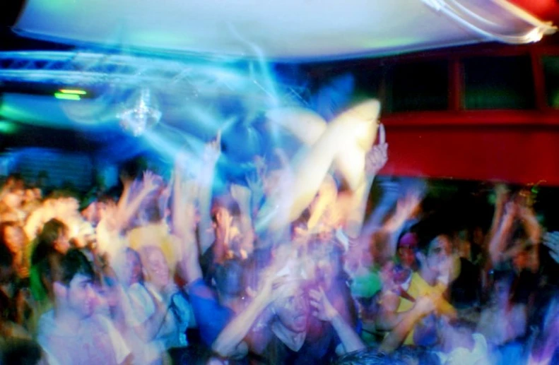a crowd of people dance at a nightclub