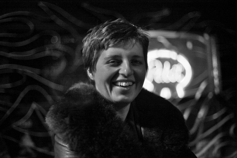 a smiling woman wearing a fur collar smiling