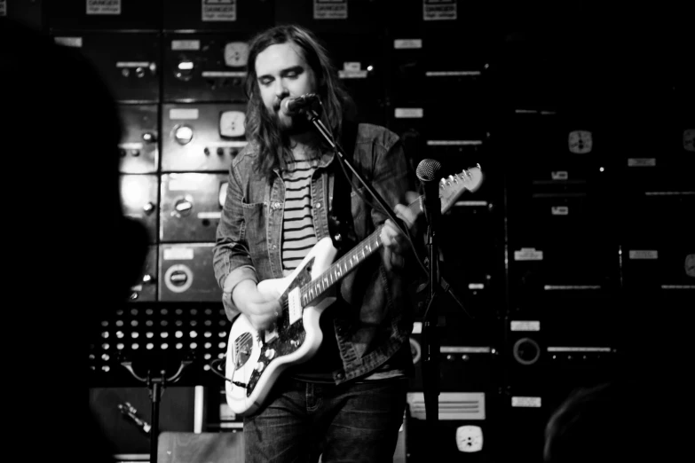 a man with long hair playing a guitar