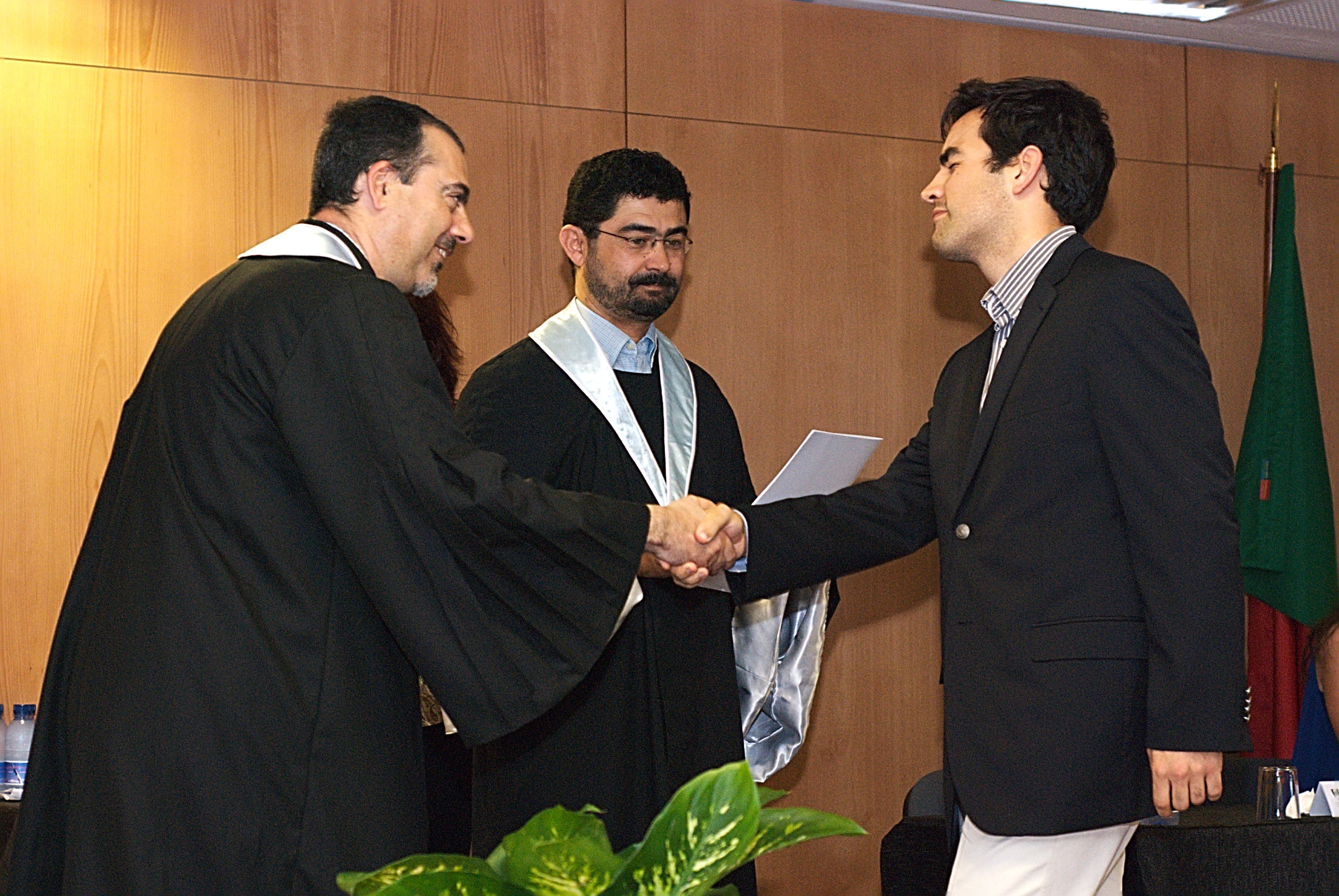 three men wearing suit and ties shaking hands