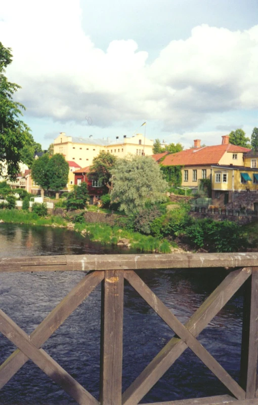 a house on the other side of a bridge with houses in the background